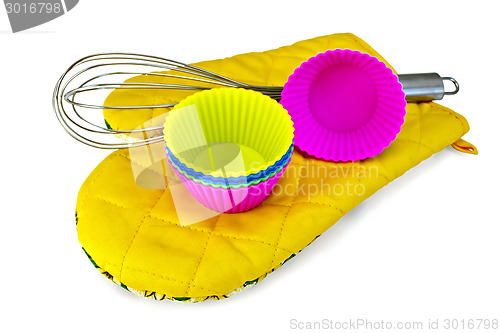 Image of Molds for cupcakes with mixer on yellow potholder