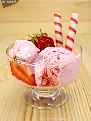 Image of Ice cream strawberry in glass goblet on board
