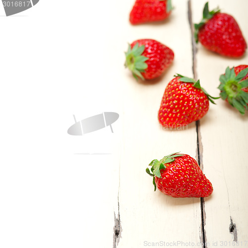 Image of fresh organic strawberry over white wood