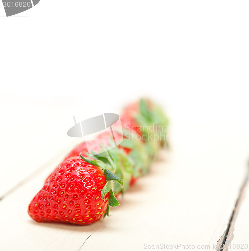 Image of fresh organic strawberry over white wood