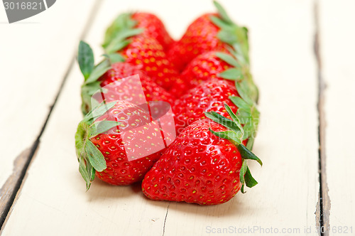 Image of fresh organic strawberry over white wood