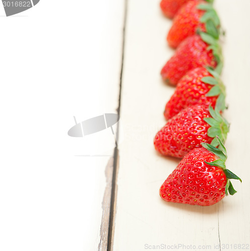 Image of fresh organic strawberry over white wood