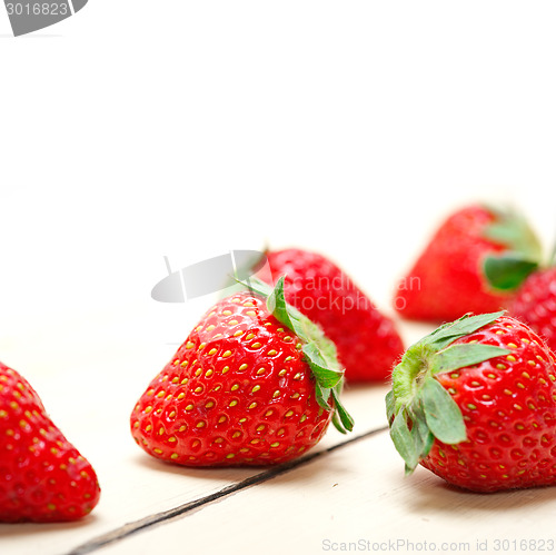 Image of fresh organic strawberry over white wood