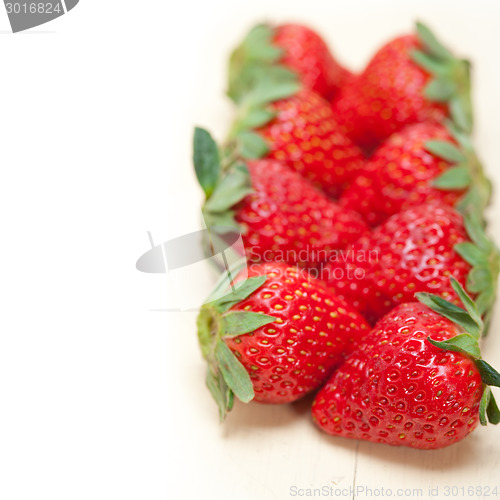 Image of fresh organic strawberry over white wood