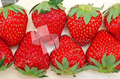 Image of fresh organic strawberry over white wood