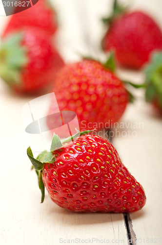 Image of fresh organic strawberry over white wood