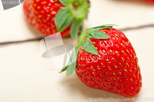 Image of fresh organic strawberry over white wood