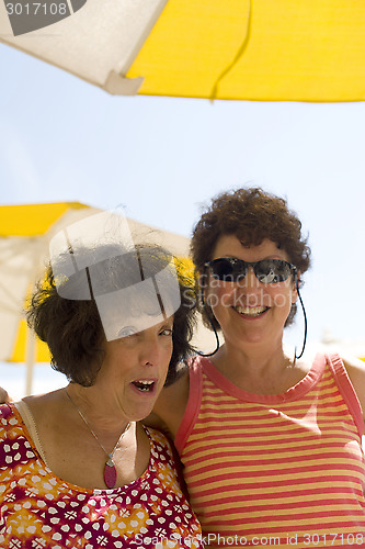 Image of two senior women friends happy at beach