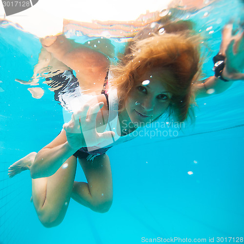 Image of Female with eyes open underwater in swimming pool