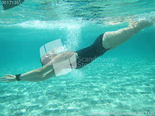 Image of Female swimmer diving underwater in ocean