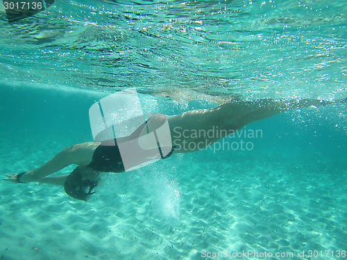 Image of Female swimmer diving underwater in ocean