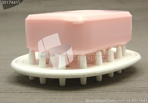 Image of Pink soap on a soap dish on a gray background