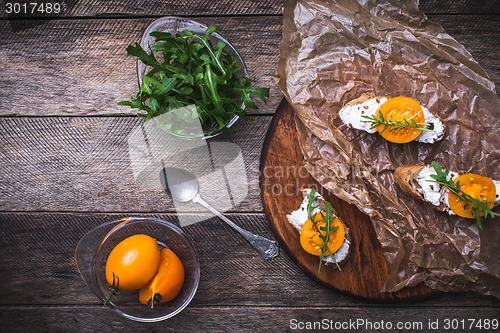 Image of Bruschetta with cheese, tomatoes and salad rocket in rustic styl