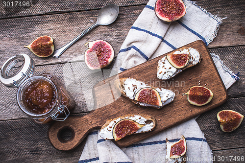 Image of Bruschetta snacks with jam and figs on napkin in rustic style