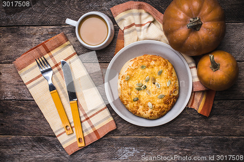 Image of Breakfast coffee and flat cake with pumpkin seeds on wooden tabl