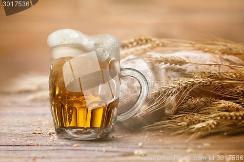 Image of Bread and wheat on wooden table, shallow DOF