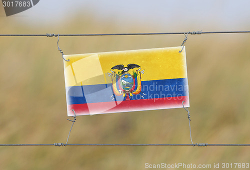 Image of Border fence - Old plastic sign with a flag