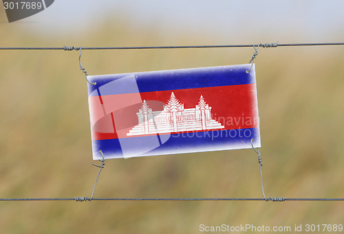 Image of Border fence - Old plastic sign with a flag