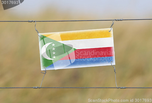 Image of Border fence - Old plastic sign with a flag