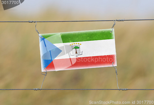 Image of Border fence - Old plastic sign with a flag