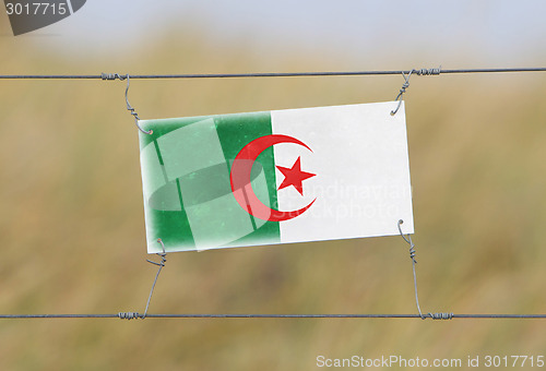 Image of Border fence - Old plastic sign with a flag