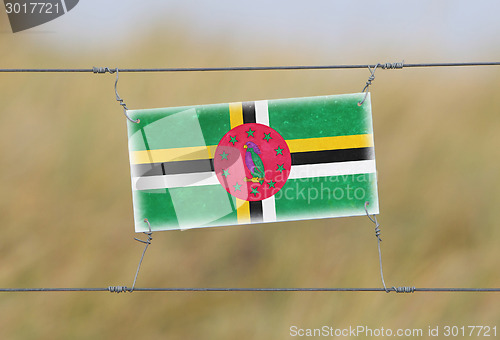 Image of Border fence - Old plastic sign with a flag