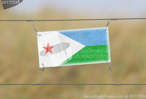 Image of Border fence - Old plastic sign with a flag