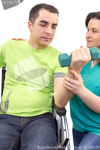 Image of Physical therapist works with patient in lifting hands weights.