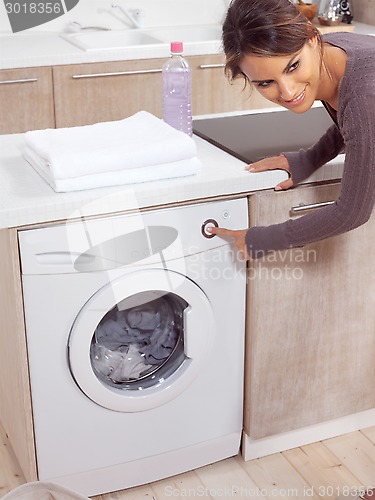 Image of female pressing button on washing machine