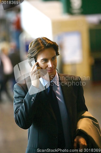 Image of Handsome businessman talking on mobile phone