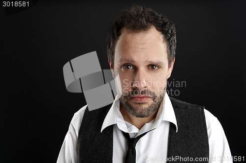 Image of Attractive  man with white shirt and black tie looks into the ca