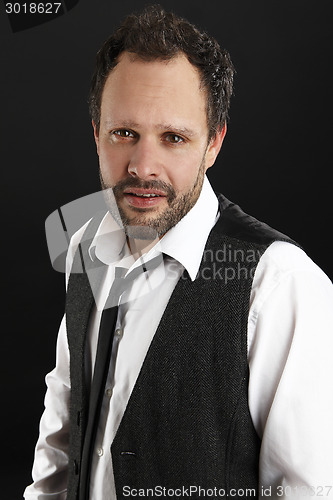 Image of Attractive  man with white shirt and black tie looks into the ca