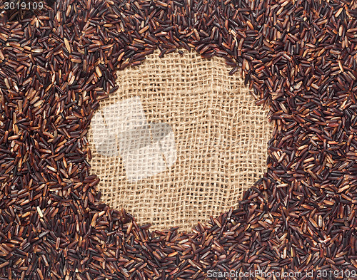 Image of Red rice on burlap fabric