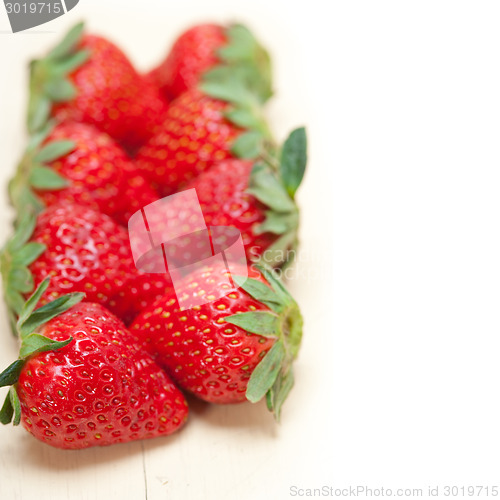 Image of fresh organic strawberry over white wood