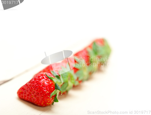 Image of fresh organic strawberry over white wood