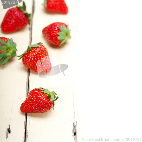 Image of fresh organic strawberry over white wood