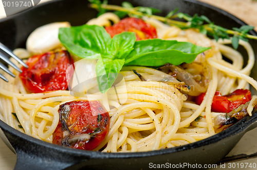 Image of spaghetti pasta with baked cherry tomatoes and basil 