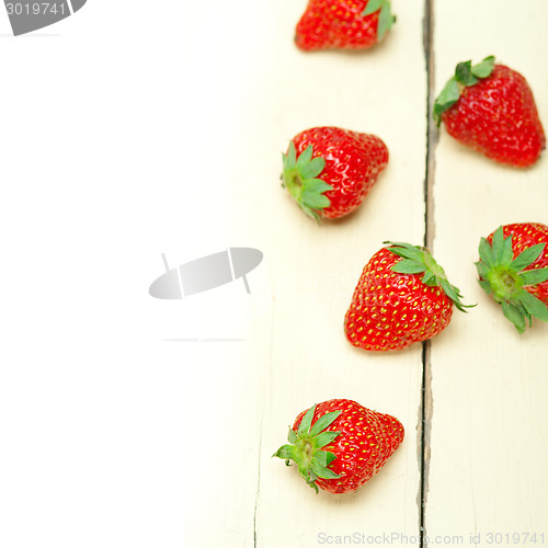 Image of fresh organic strawberry over white wood