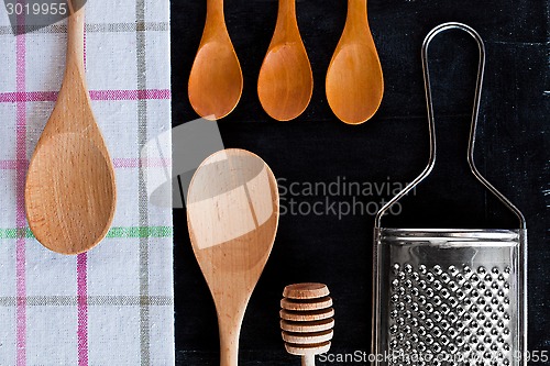 Image of wooden spoons, metal grater and tablecloth