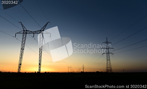 Image of Large transmission towers at sunset