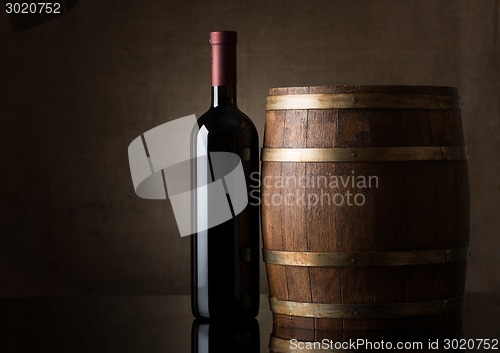 Image of Bottle and a wooden barrel