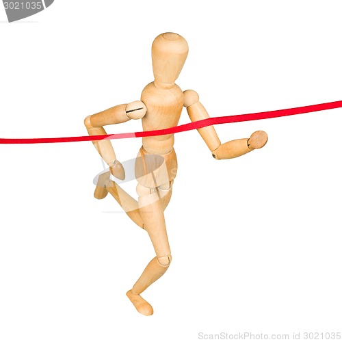 Image of Wooden mannequin running through finishing line