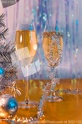 Image of Glasses with wine, tinsel, Christmas tree and toys