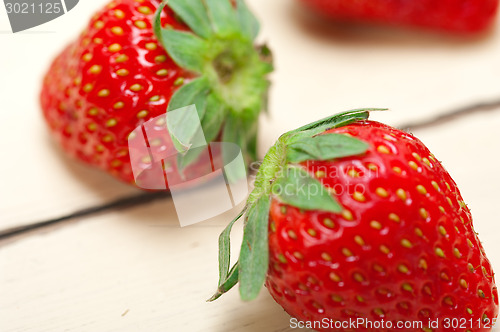 Image of fresh organic strawberry over white wood