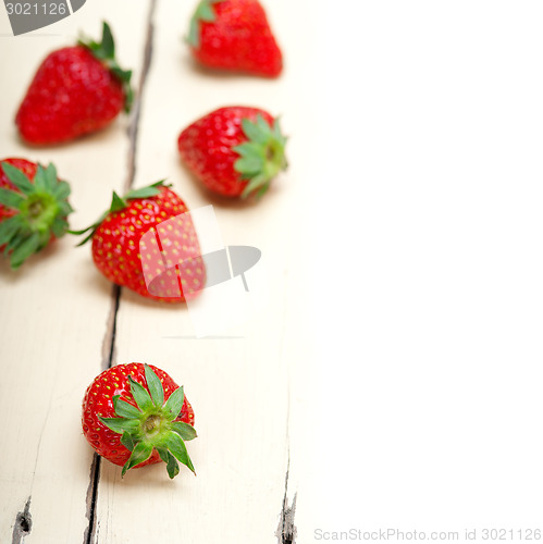 Image of fresh organic strawberry over white wood