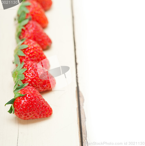 Image of fresh organic strawberry over white wood