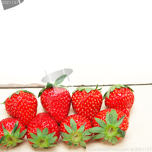 Image of fresh organic strawberry over white wood