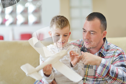 Image of father and son assembling airplane toy