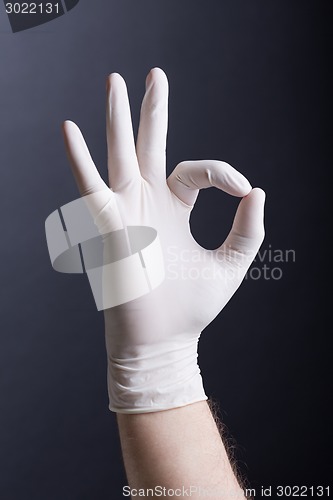 Image of Male hand in latex glove (OK sign)