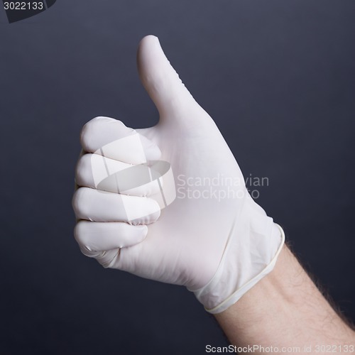 Image of Male hand in latex glove (thumb up sign)